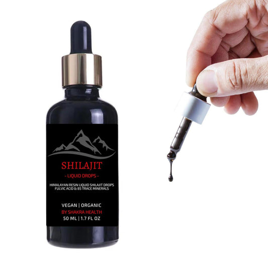 Hand holding a glass dropper dispensing dark Himalayan Shilajit liquid next to a 50ml amber bottle with mountain label.