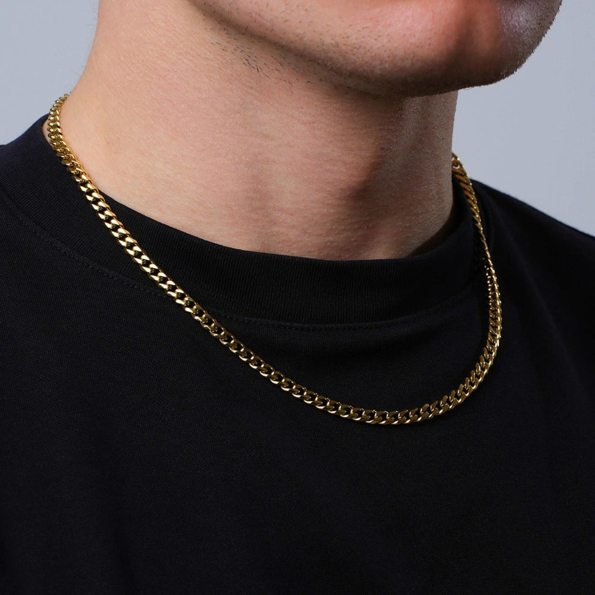 5mm 18K gold plated Cuban link chain necklace worn on a man in a black t-shirt.