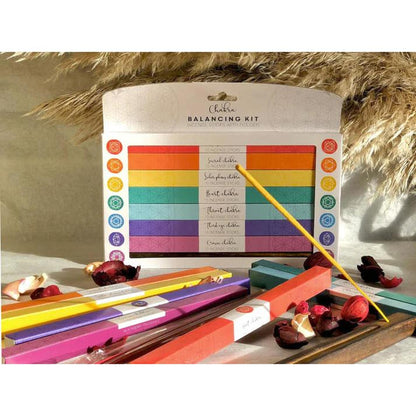 7 Chakra incense gift set with colorful boxes, bamboo sticks, and a wooden holder on a neutral background.