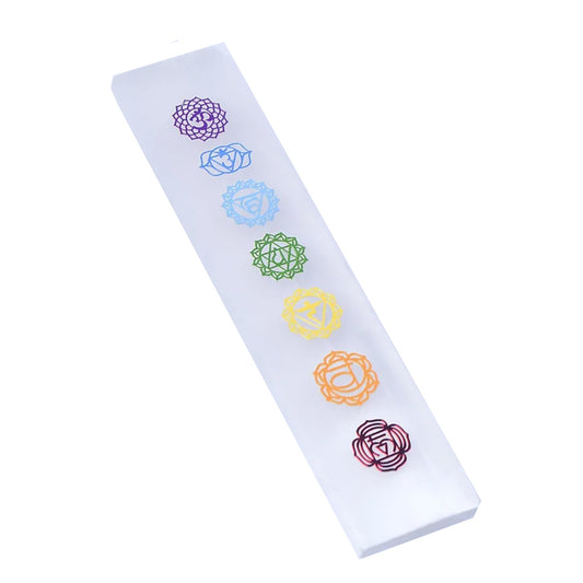 Rectangular white Moroccan selenite charging bar engraved with seven colorful chakra symbols on a clear background.