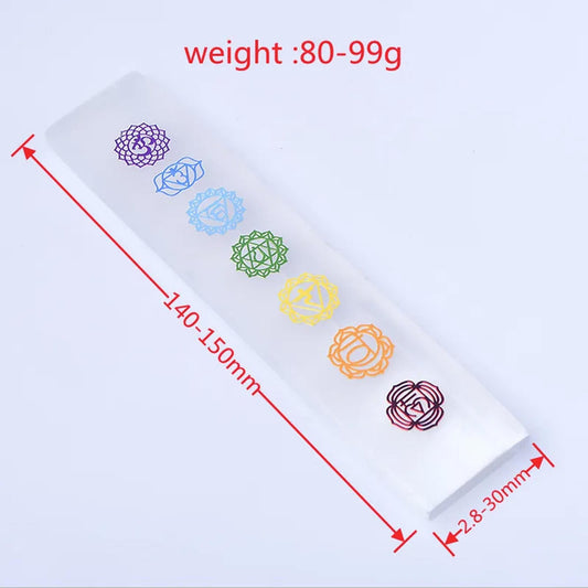 Rectangular white selenite charging bar featuring seven colorful engraved chakra symbols on a clean surface.