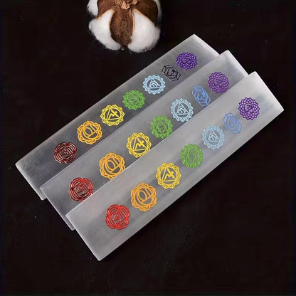 Rectangular white Moroccan selenite charging bars featuring colorful engraved seven chakra symbols.