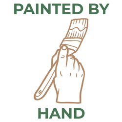 Hand-drawn illustration of a hand holding a paintbrush with the text PAINTED BY HAND in dark green.