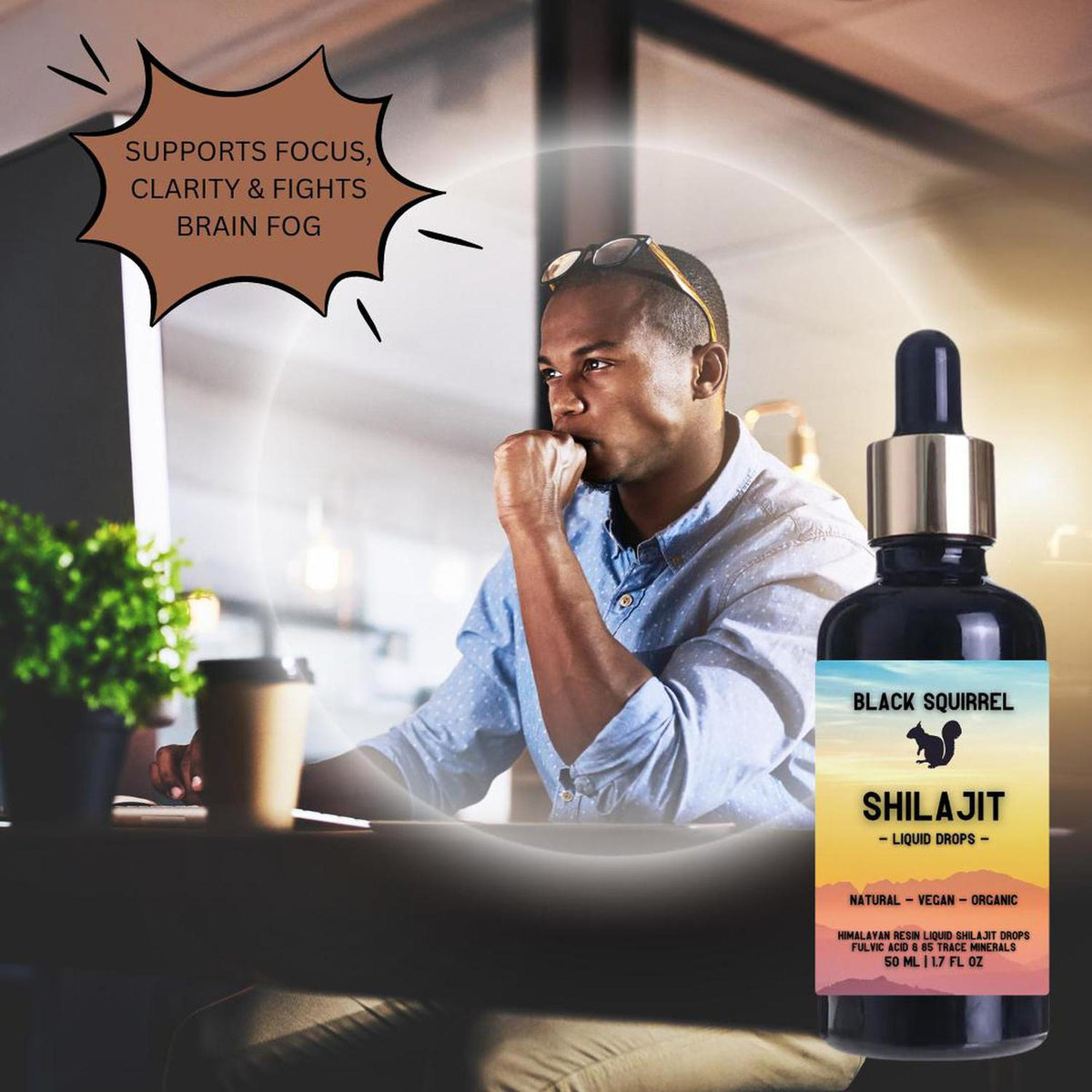 Black Squirrel 50ml Shilajit liquid dropper bottle next to a focused professional working at a computer.