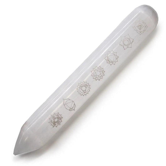 White selenite crystal wand engraved with seven chakra symbols on a white background.