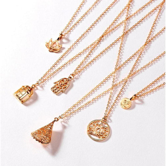 Gold-toned minimalist necklaces featuring spiritual symbols like a lotus, hamsa hand, and cage charms on delicate chains.