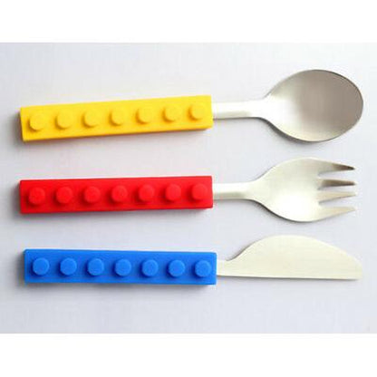 Kids' stacking cutlery set with stainless steel spoon, fork, and knife featuring colorful, block-style silicone handles.