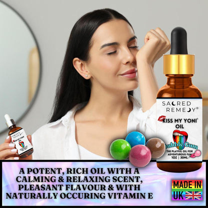Woman smelling Kiss My Yoni Oil bubblegum scent in an amber dropper bottle with colorful gumballs on a branded background.