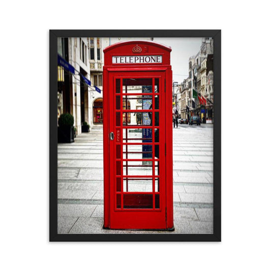 Vibrant red London telephone booth framed poster on a neutral city street background with a sleek black frame.