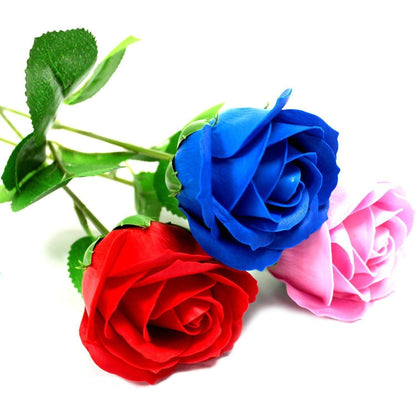 Three realistic soap roses in red, blue, and pink with green stems and leaves on a white background.