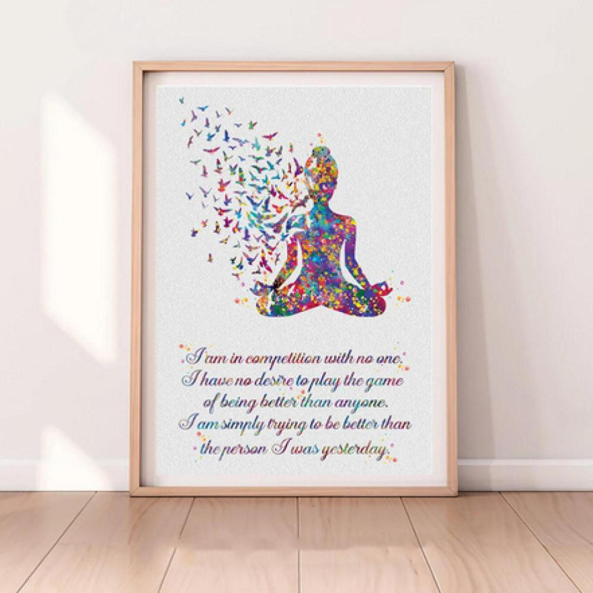 Watercolor Buddha canvas print with colorful butterflies and motivational quote in a light wood frame on a wall.