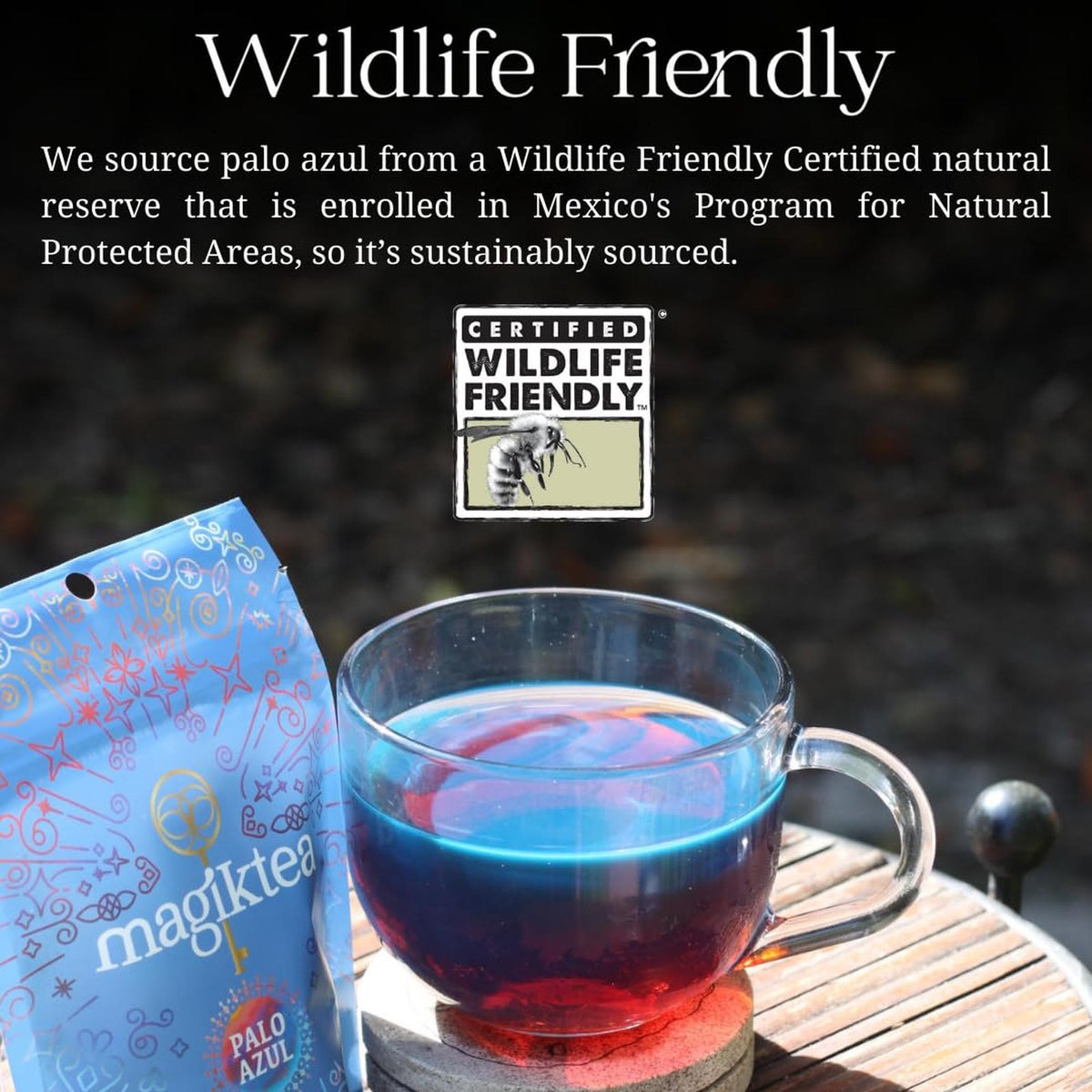 Glass cup of glowing blue Palo Azul tea next to a Magiktea pouch with a Wildlife Friendly certification logo.