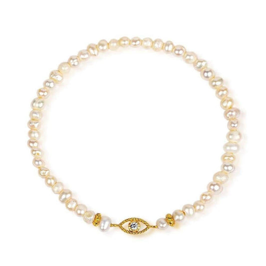 Stretch bracelet featuring natural pearls and a gold-plated evil eye charm with a central cubic zirconia stone.