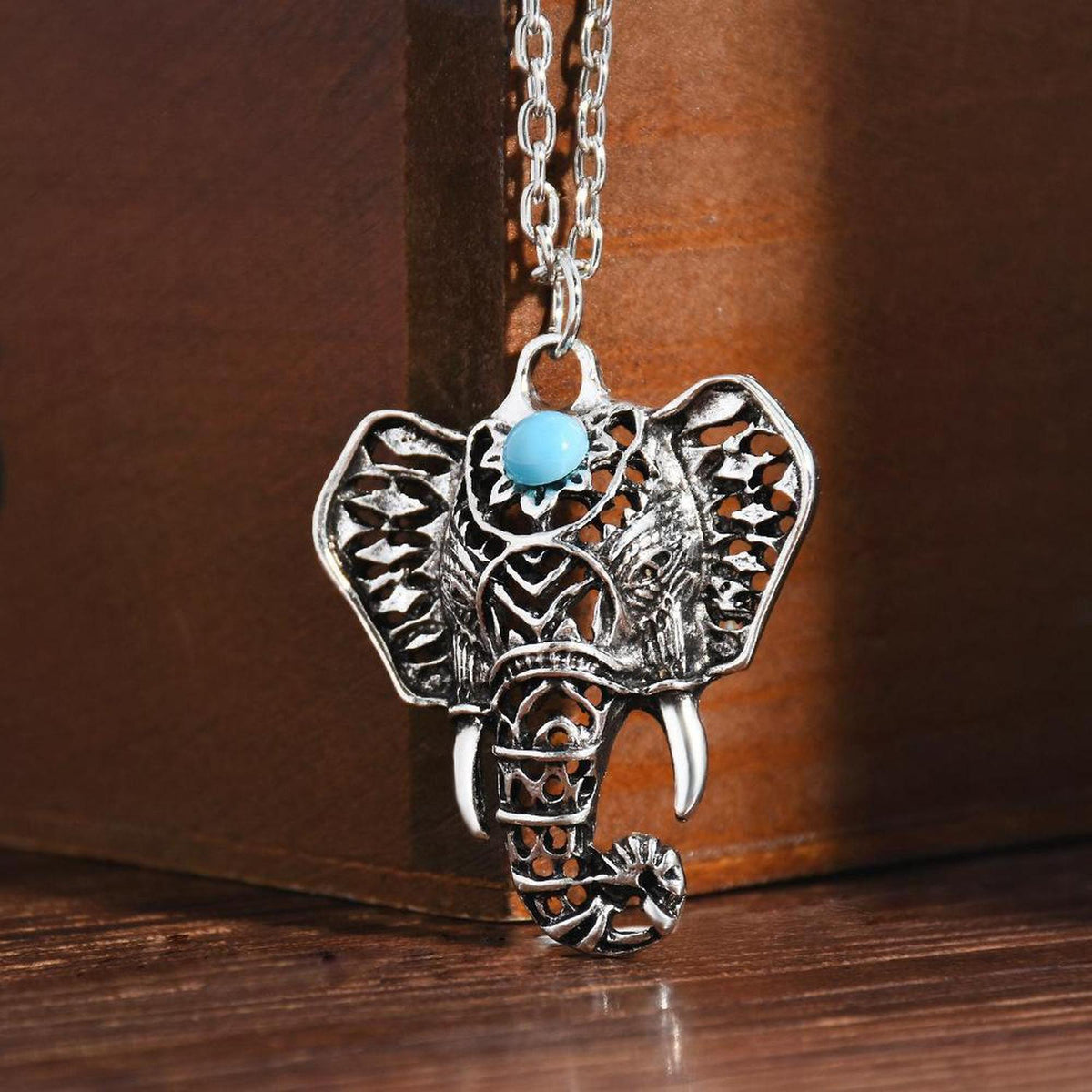 Antique silver-plated elephant pendant necklace featuring an intricate cutout design and a central mystic blue stone.