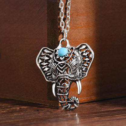 Antique silver-plated elephant pendant necklace featuring an intricate cutout design and a central mystic blue stone.
