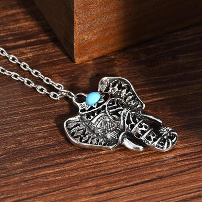 Antique silver elephant pendant necklace featuring a small, vibrant blue stone on a delicate silver chain.