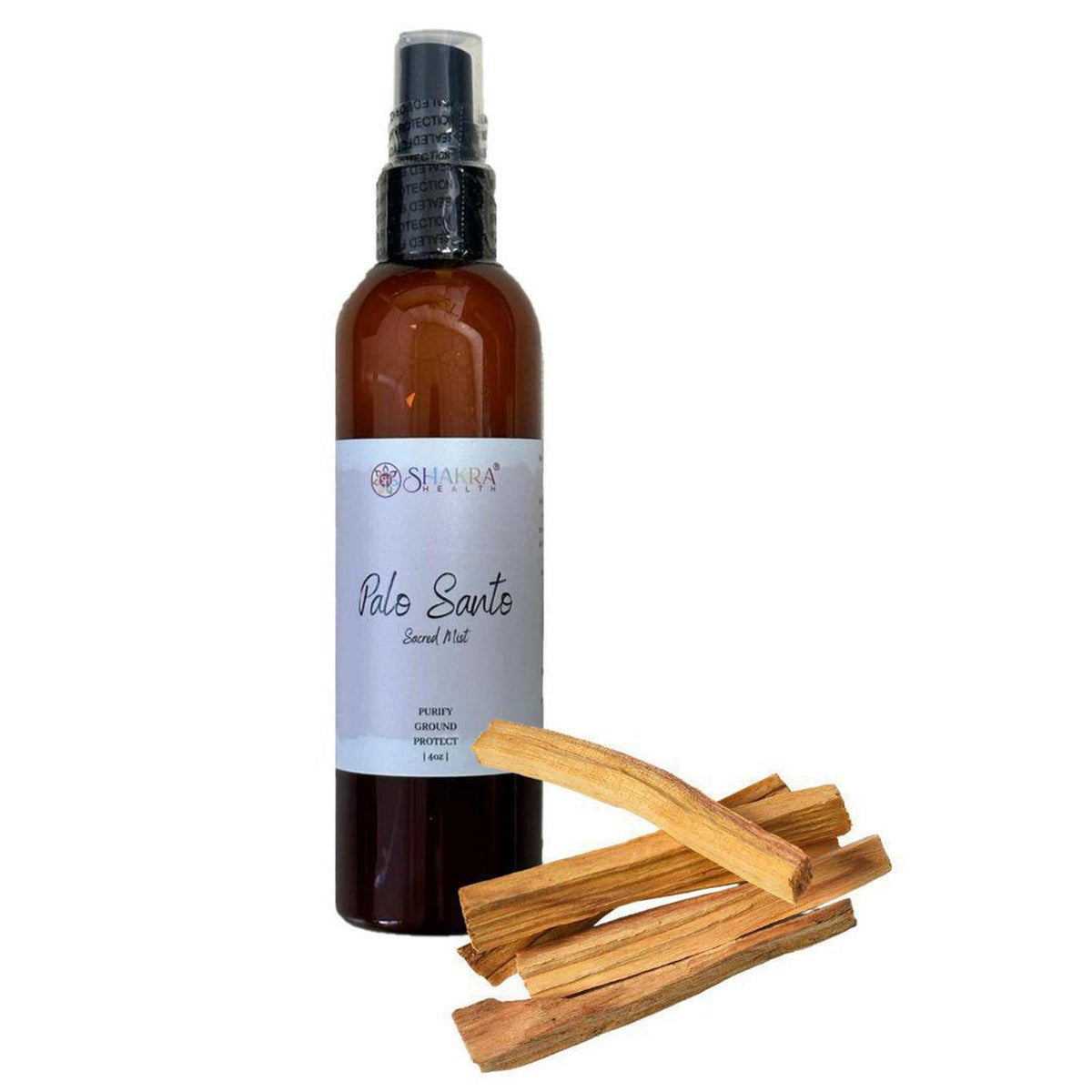 Amber 4oz spray bottle of Palo Santo Sacred Mist with a white label next to a small pile of raw Palo Santo wood sticks.