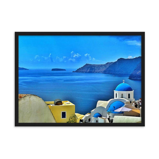 Framed Santorini landscape print featuring blue-domed churches and yellow architecture overlooking the Aegean Sea.