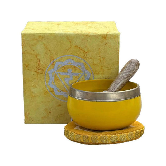 Yellow brass singing bowl with wooden mallet, matching cushion, and yellow gift box featuring a chakra symbol.