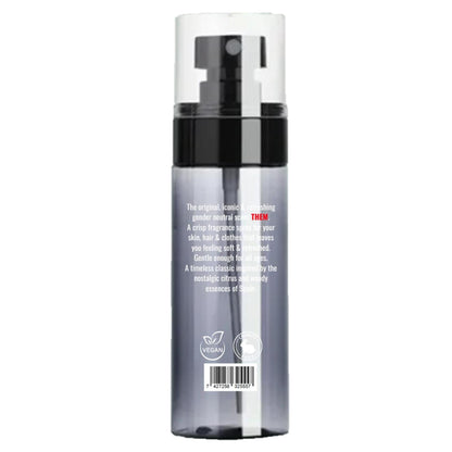 Clear spray bottle of THEM Agua de Colonia with black pump, white text, and vegan and cruelty-free icons on a gray base.