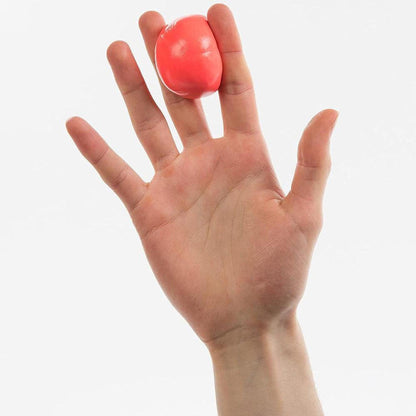 Hand squeezing a smooth, vibrant coral-colored therapy putty ball for hand strength and rehabilitation exercises.