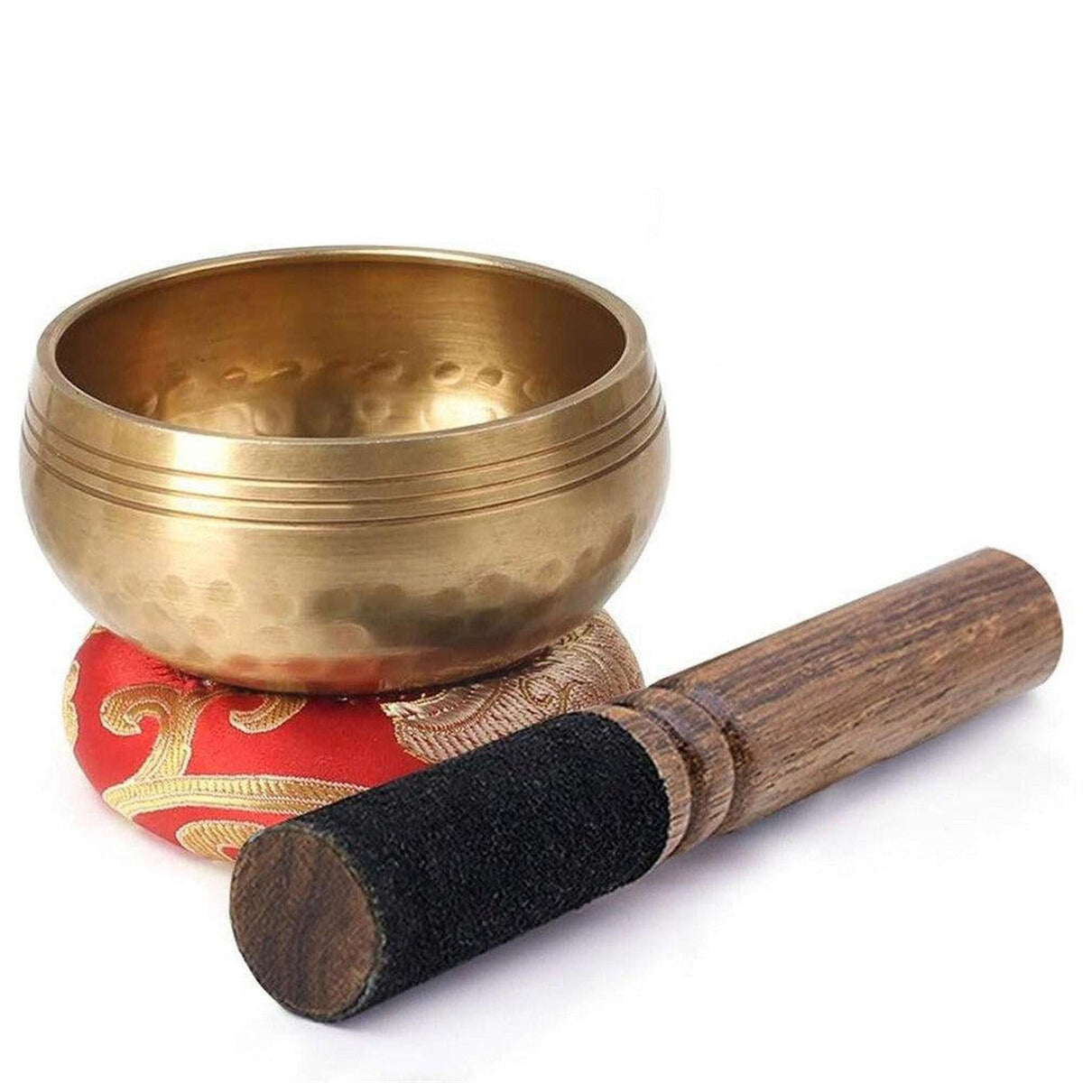 Handcrafted copper Tibetan singing bowl with a wooden striker on a decorative red and gold silk cushion.