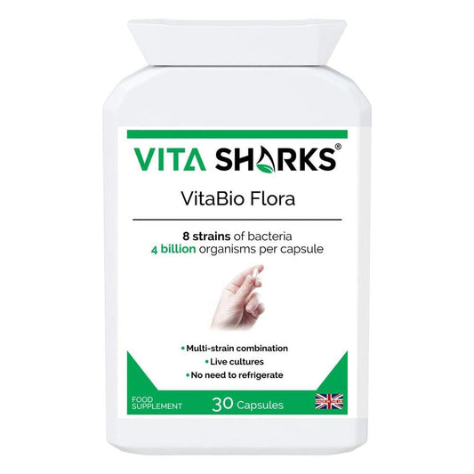 White bottle of VitaBio Flora probiotic capsules with green branding, text details, and a hand holding a single capsule.
