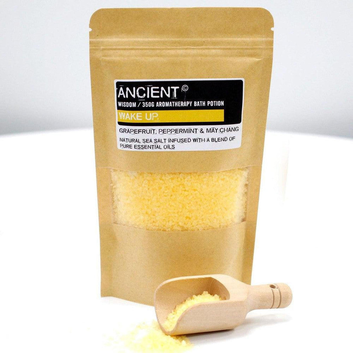350g Wake Up sea salt bath potion in a brown kraft pouch with a small wooden scoop and yellow salt crystals.