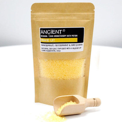 350g Wake Up sea salt bath potion in a brown kraft pouch with a small wooden scoop and yellow salt crystals.