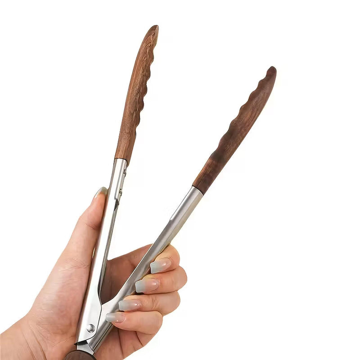 Hand holding kitchen tongs with stainless steel frames and natural walnut wood heads for non-stick cookware.